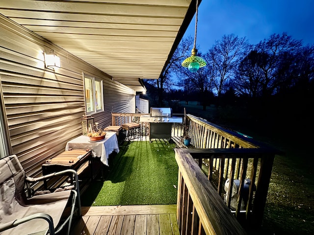 wooden deck featuring a lawn and a grill