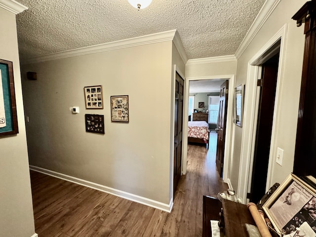 corridor featuring a textured ceiling, dark hardwood / wood-style floors, and ornamental molding