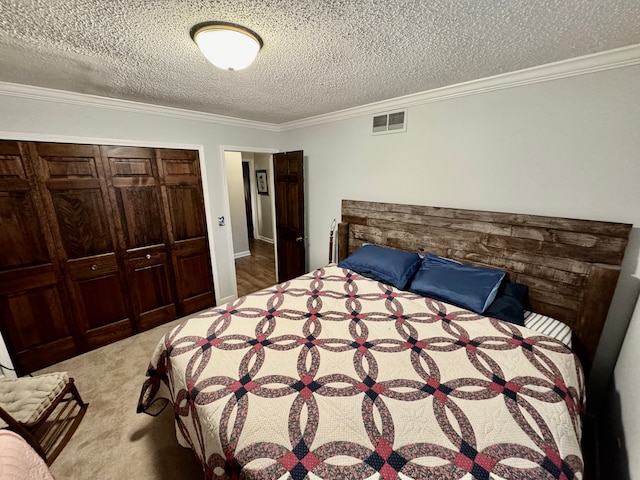 carpeted bedroom with ornamental molding, a textured ceiling, and a closet