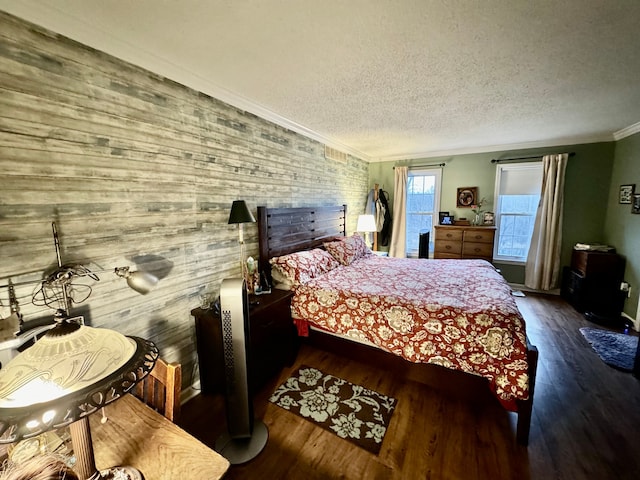 bedroom featuring dark wood-type flooring, a textured ceiling, and ornamental molding