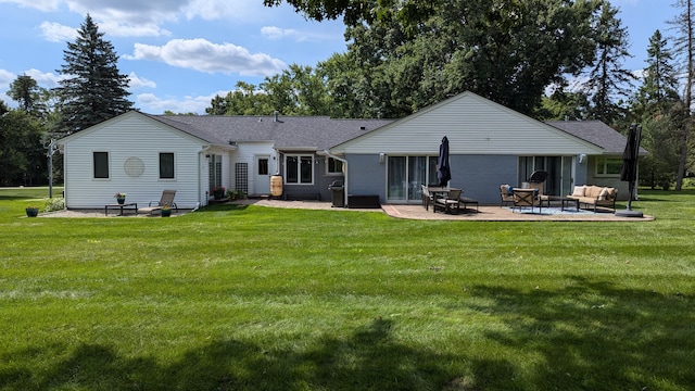 back of property with a patio area, a yard, and an outdoor hangout area