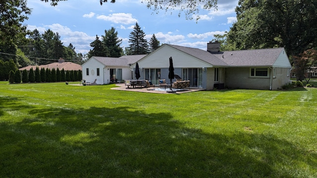 rear view of property featuring a lawn and a patio