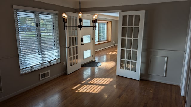 doorway to outside featuring dark hardwood / wood-style floors, french doors, and an inviting chandelier