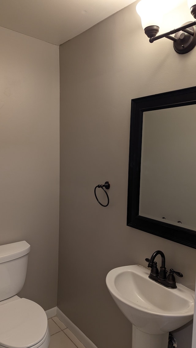 bathroom with sink, toilet, and tile patterned flooring