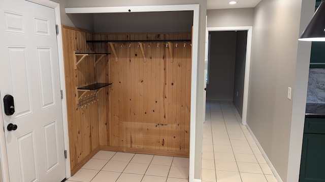 bathroom featuring wooden walls and tile patterned flooring