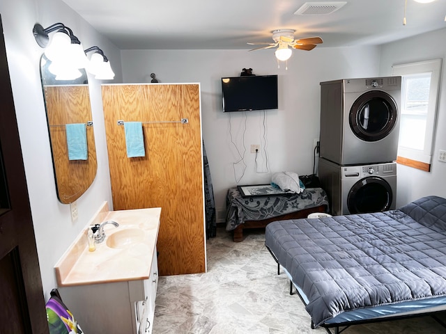 interior space featuring stacked washer / dryer, ceiling fan, and vanity