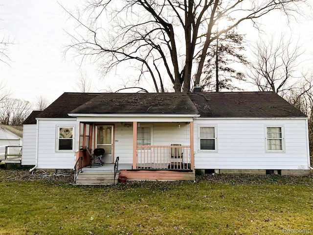 2360 Virginia Ave, Saginaw, MI 48601 - view of front facade with covered porch, a front lawn, and roof with shingles