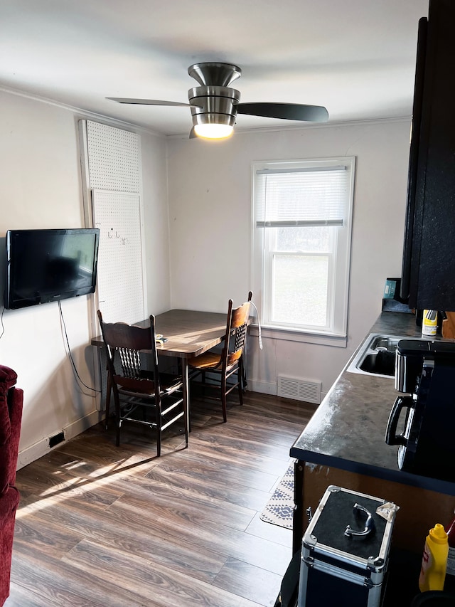 dining room with ceiling fan, dark wood-type flooring, and sink