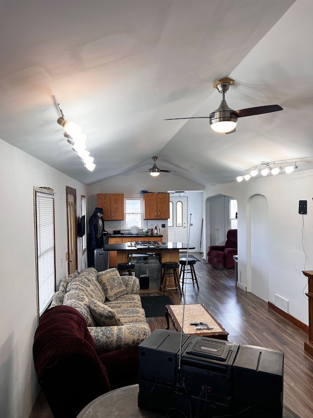 living room featuring dark hardwood / wood-style floors, ceiling fan, and lofted ceiling