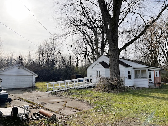 view of home's exterior featuring a yard, a garage, and an outdoor structure