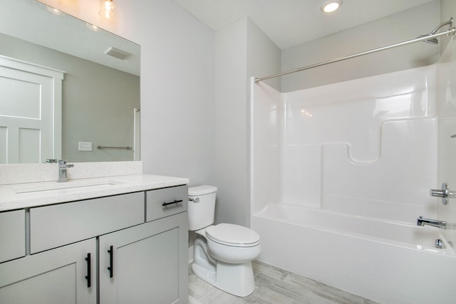 full bathroom with hardwood / wood-style flooring, shower / washtub combination, vanity, and toilet