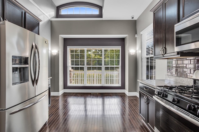 kitchen with dark brown cabinetry, light stone counters, dark hardwood / wood-style flooring, and stainless steel appliances