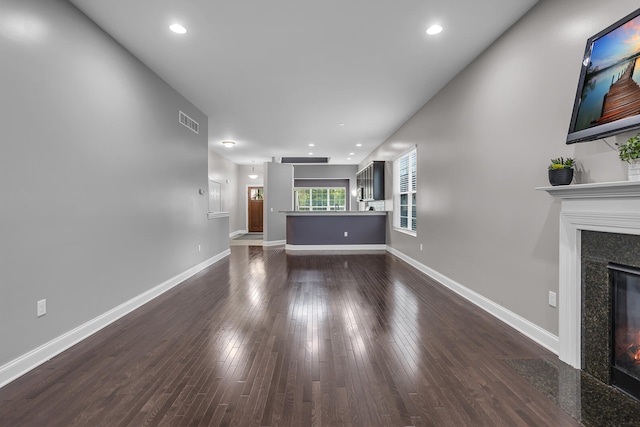 unfurnished living room with dark hardwood / wood-style floors and a high end fireplace