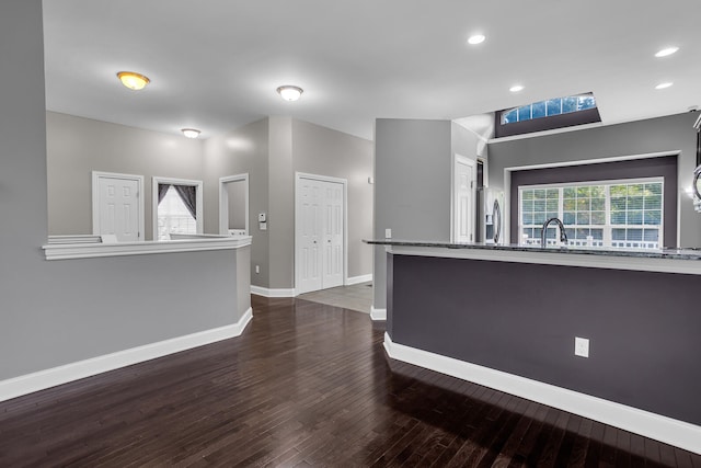 kitchen featuring dark hardwood / wood-style flooring, stainless steel refrigerator with ice dispenser, and sink