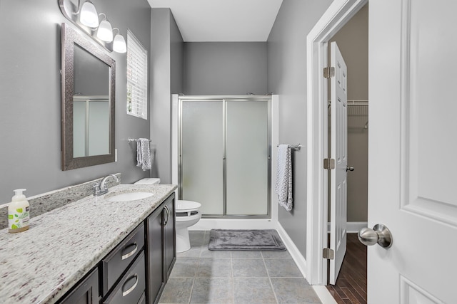 bathroom featuring hardwood / wood-style floors, vanity, an enclosed shower, and toilet