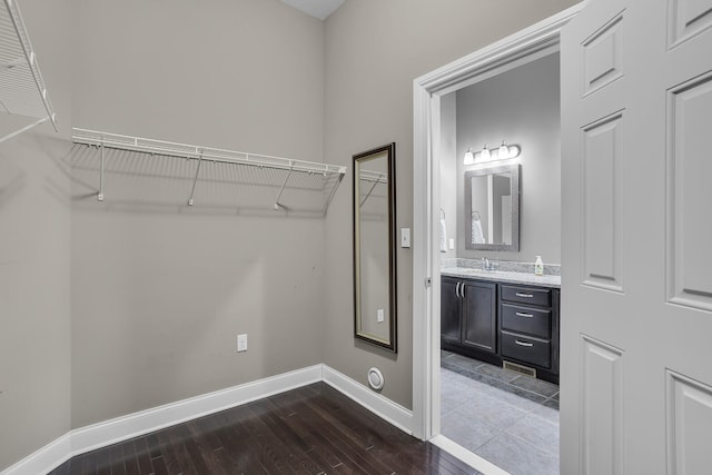 spacious closet featuring dark hardwood / wood-style flooring and sink