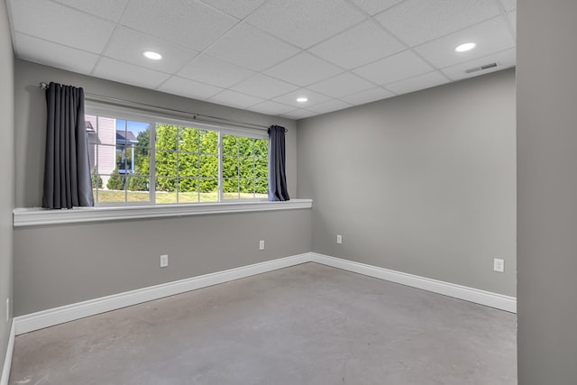 spare room featuring a drop ceiling and concrete flooring