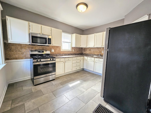 kitchen featuring white cabinets, decorative backsplash, sink, and appliances with stainless steel finishes