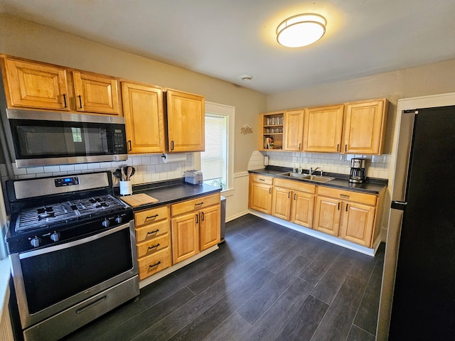 kitchen with appliances with stainless steel finishes, backsplash, dark wood-type flooring, and sink