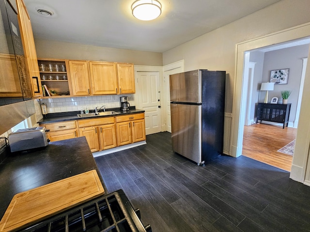 kitchen featuring backsplash, stainless steel refrigerator, sink, and dark hardwood / wood-style floors