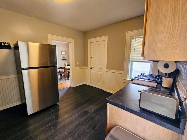 kitchen with stainless steel fridge, dark hardwood / wood-style flooring, and light brown cabinets