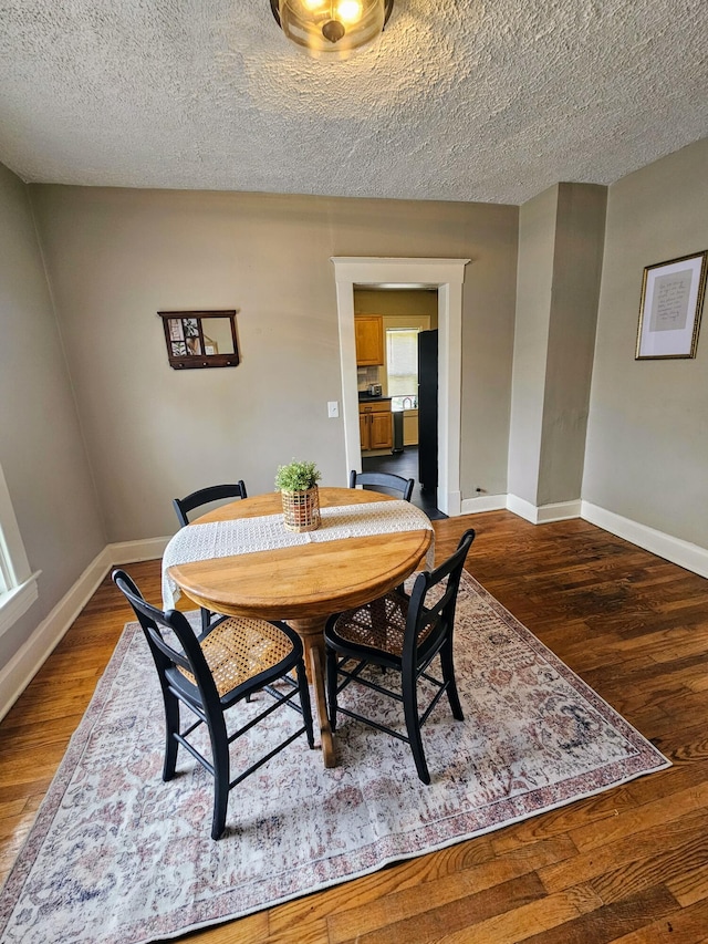 dining area featuring a textured ceiling and dark wood-type flooring