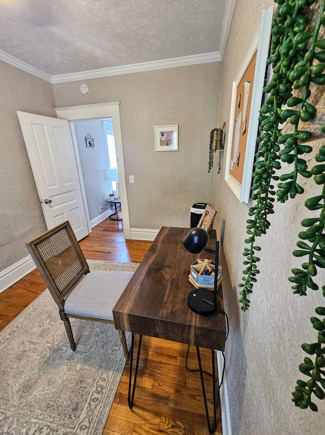 home office featuring hardwood / wood-style flooring, ornamental molding, and a textured ceiling