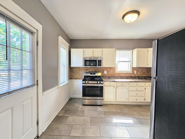 kitchen featuring a wealth of natural light, appliances with stainless steel finishes, and tasteful backsplash