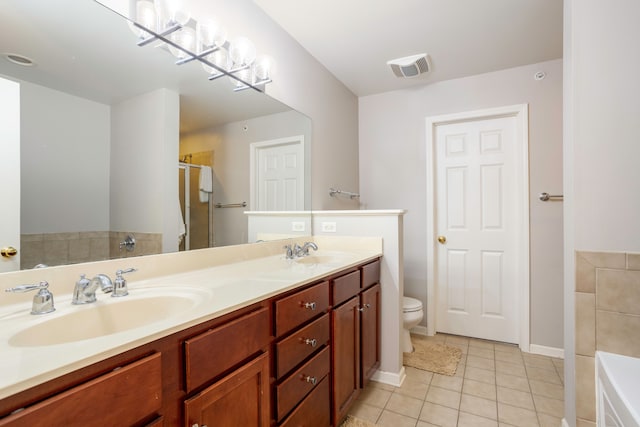 bathroom with tile patterned flooring, vanity, toilet, and a bathing tub