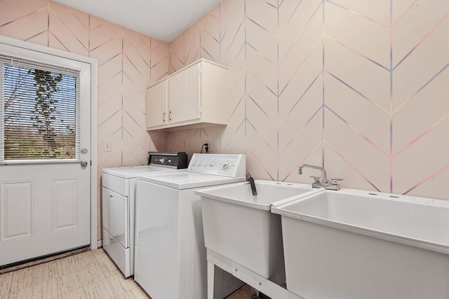 clothes washing area featuring cabinets and washing machine and clothes dryer