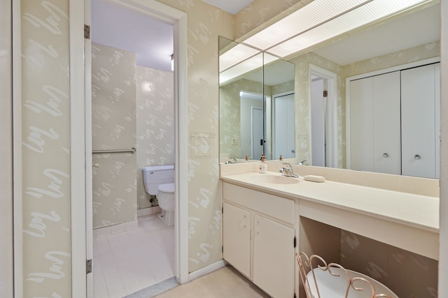 bathroom with tile patterned flooring, vanity, and toilet