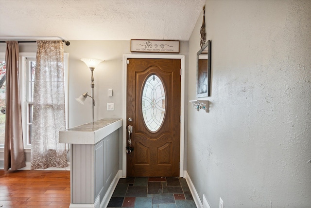 entryway with dark hardwood / wood-style flooring and a textured ceiling