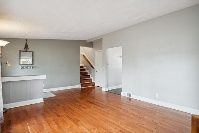 interior space featuring a textured ceiling, lofted ceiling, and hardwood / wood-style flooring