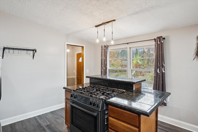 kitchen with a center island, dark hardwood / wood-style floors, gas stove, and a textured ceiling