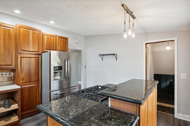 kitchen with decorative backsplash, a kitchen island, hanging light fixtures, and stainless steel refrigerator with ice dispenser