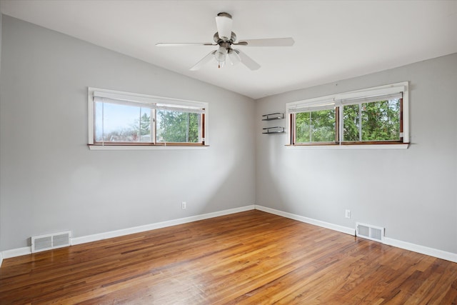 empty room featuring hardwood / wood-style floors, plenty of natural light, ceiling fan, and vaulted ceiling