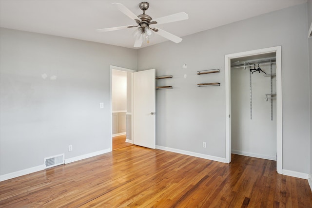 unfurnished bedroom with hardwood / wood-style floors, ceiling fan, and a closet