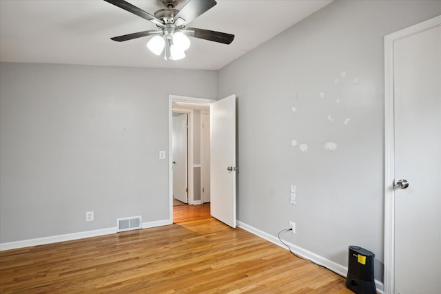 empty room with ceiling fan, light hardwood / wood-style floors, and vaulted ceiling