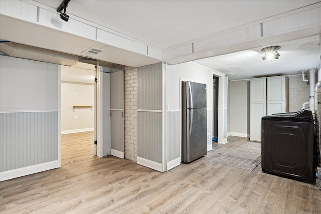 kitchen featuring light hardwood / wood-style floors, washer / clothes dryer, and stainless steel refrigerator