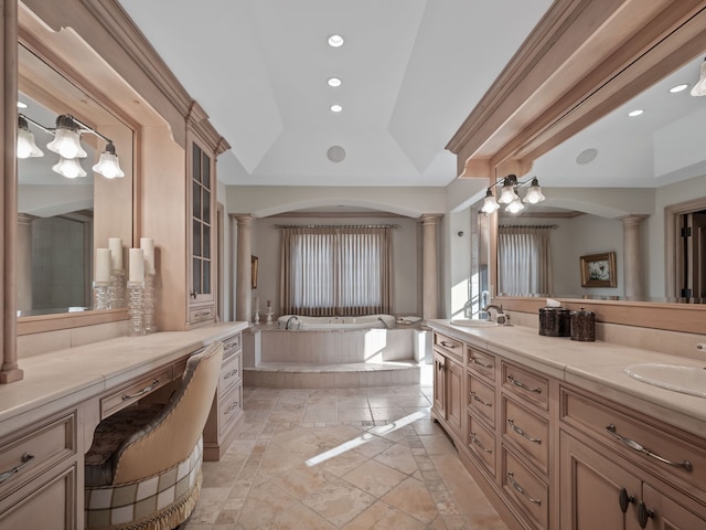 bathroom featuring decorative columns, vanity, a relaxing tiled tub, and lofted ceiling