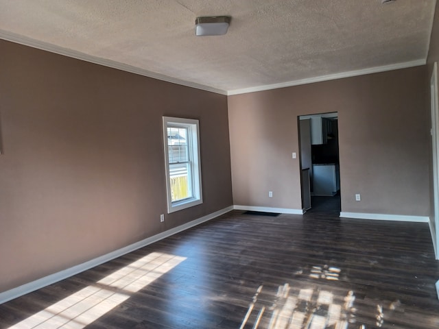 empty room featuring ornamental molding, dark hardwood / wood-style floors, and a textured ceiling