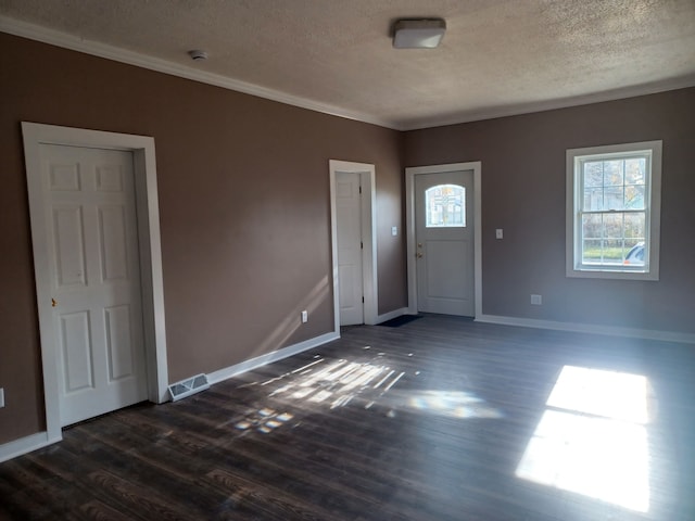 foyer featuring crown molding, dark wood-type flooring, and a textured ceiling