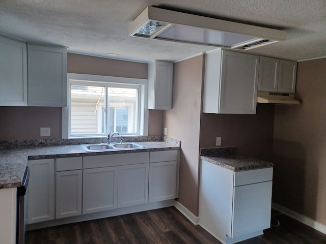 kitchen featuring dark wood-type flooring, sink, a textured ceiling, and white cabinets