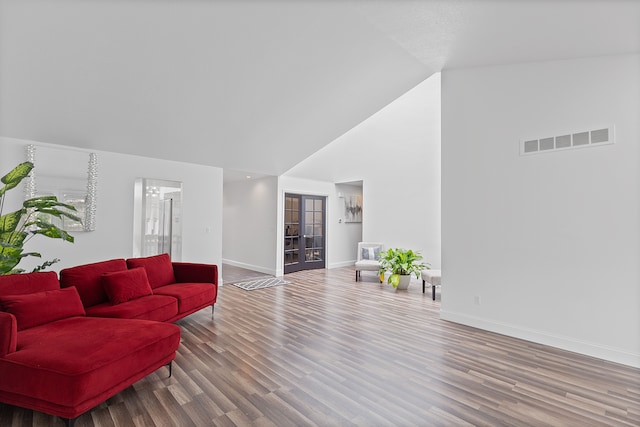 living room featuring hardwood / wood-style floors, high vaulted ceiling, and french doors