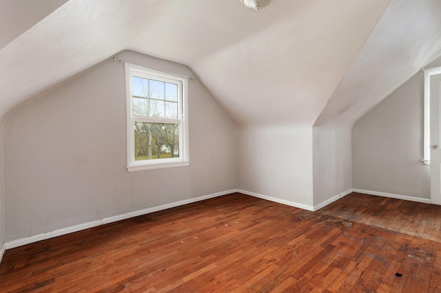 additional living space with dark hardwood / wood-style flooring and vaulted ceiling