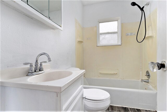 full bathroom with bathtub / shower combination, vanity, hardwood / wood-style flooring, and toilet