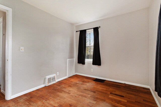 empty room with hardwood / wood-style flooring