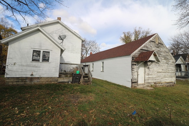 rear view of property with a lawn and a deck