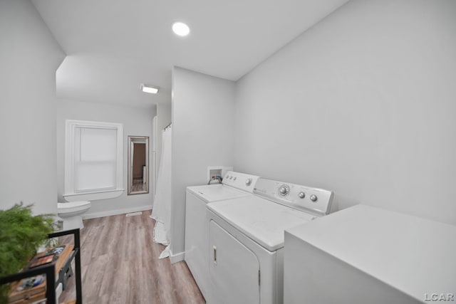 washroom featuring washer and dryer and light hardwood / wood-style flooring