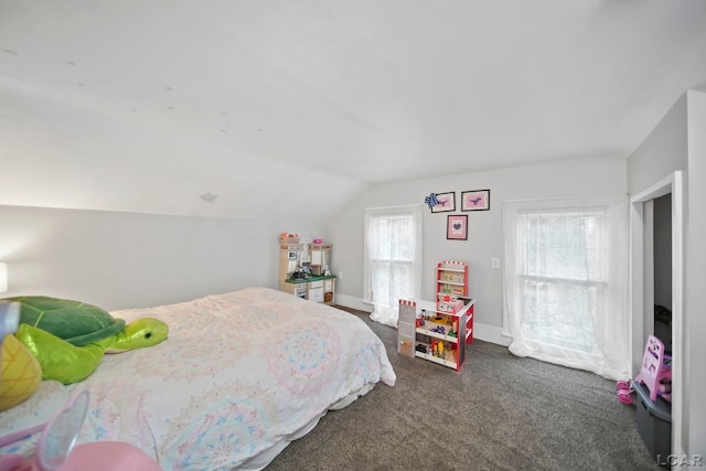 bedroom with vaulted ceiling and dark colored carpet